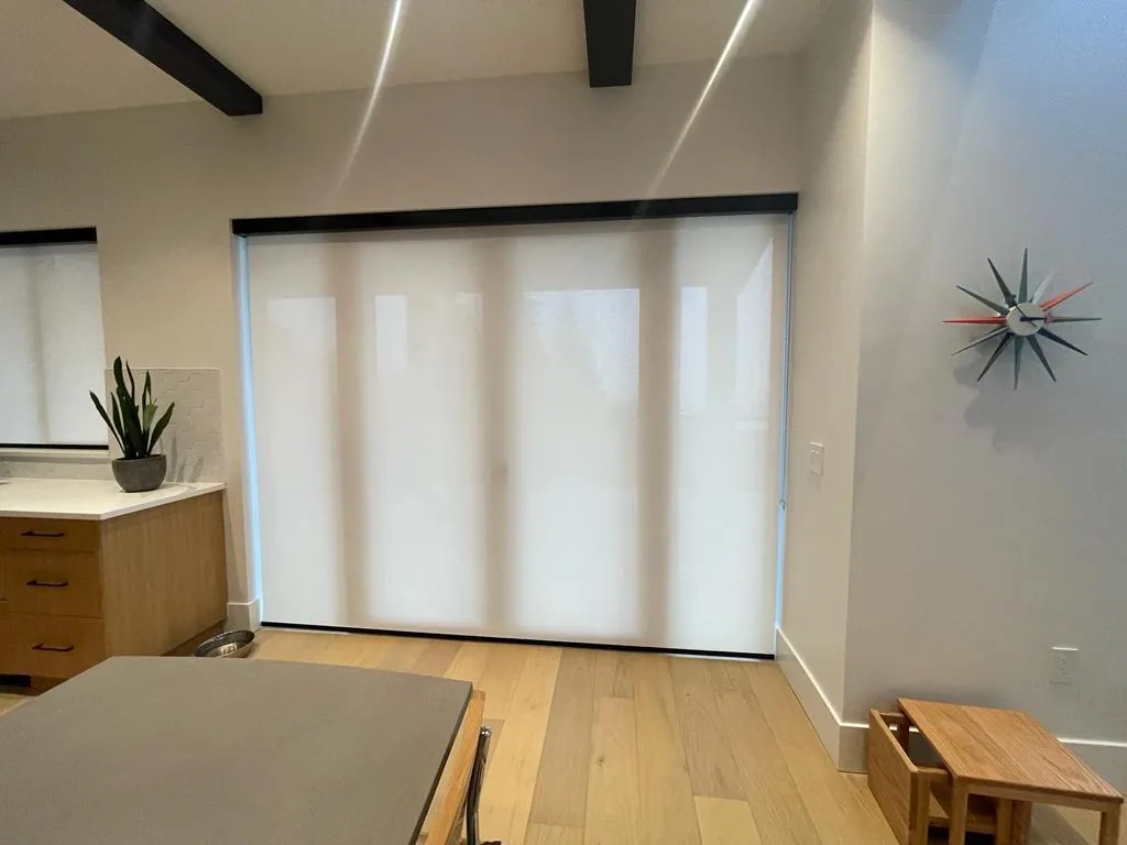 One large light-filtering roller blind covering a patio door in Edmonton